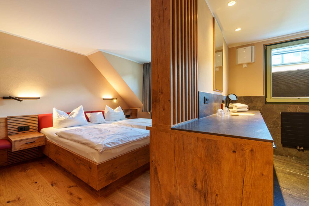 Kamers in het Ahrdal: Moderne tweepersoonskamers in het Ahrdal: Boutique kamers in Hotel Ruland in Altenahr met veel ruimte, een regendouche en een stijlvol design.